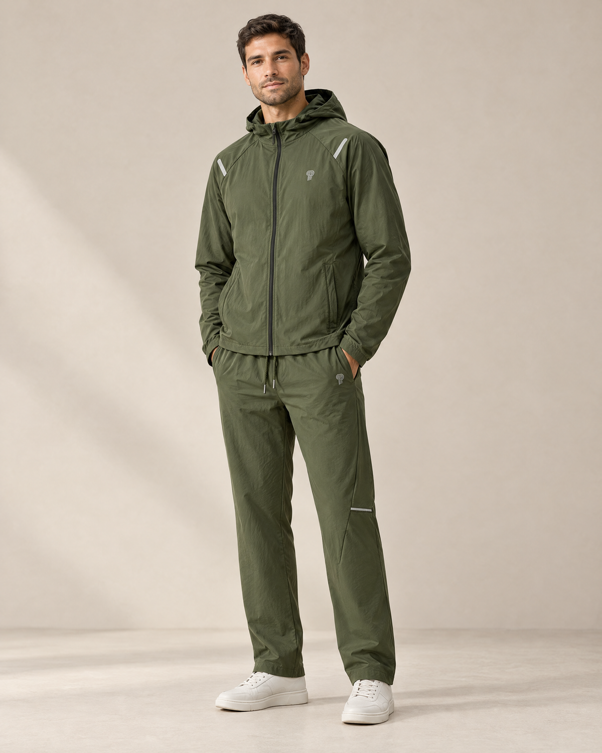Tracksuits — adult man wearing the Army Green Voyage full-zip hooded jacket and matching full-length trousers.