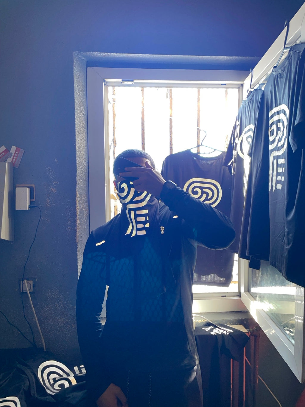Original Polocom Plus archive photograph of the black quarter-zip worn with a branded face covering.